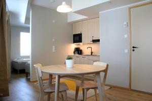 a kitchen and dining room with a table and chairs at Spot Apartments Airport Premium in Vantaa