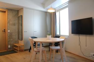 a dining room with a table and chairs and a tv at Spot Apartments Airport Premium in Vantaa