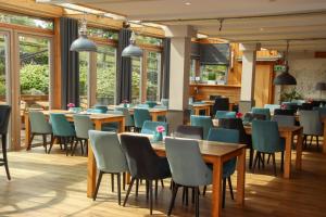 a restaurant with wooden tables and chairs and windows at Xavers Ranch in Meschede