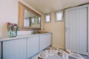 a bathroom with white cabinets and a mirror at Alma Libre Villas in Kastraki +67 photos