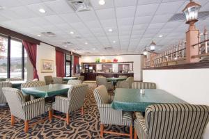 a dining room with green tables and chairs at Quality Inn Oneonta Cooperstown Area in Oneonta