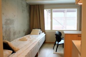 a small bedroom with a bed and a window at Spot Apartments Airport Premium in Vantaa