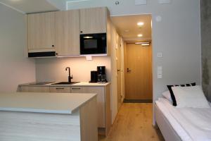 a small kitchen with a counter and a bed in a room at Spot Apartments Airport Premium in Vantaa +26 photos