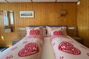 a bedroom with two beds with red and white pillows at Studio bim Chalet bim Chilchli in Mürren