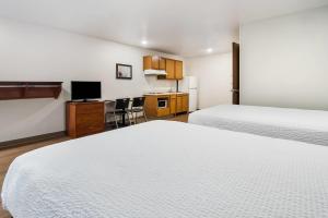 a hotel room with two beds and a kitchen at WoodSpring Suites Abilene in Abilene