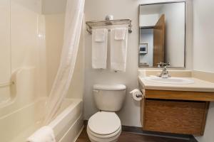 a bathroom with a white toilet and a sink at WoodSpring Suites Abilene in Abilene +23 photos