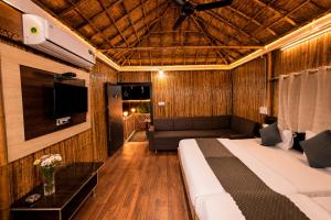 a hotel room with a bed and a couch at Hotel Happy Forest -Boutique Garden Retreat in Mount Abu in Mount Ābu