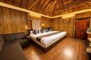 a bedroom with a large bed and a couch at Hotel Happy Forest -Boutique Garden Retreat in Mount Abu in Mount Ābu +37 photos