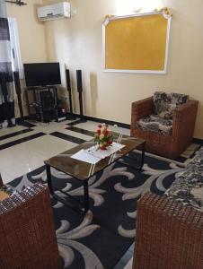 a living room with a coffee table and a chair at Palace Ndogbong Bifaga in Bassa
