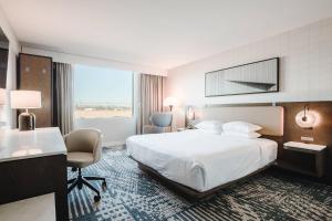 a hotel room with a bed and a desk and chairs at Radisson Hotel Santa Maria in Santa Maria