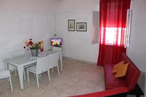 TriscinaにあるAppartamento Mediterraneoのリビングルーム(テーブル、赤いカーテン付)
