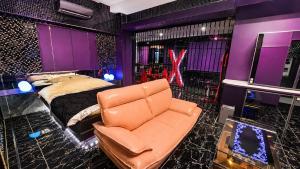 a bedroom with a bed and a leather couch at Fire Hotel Nw in Saitama +22 photos