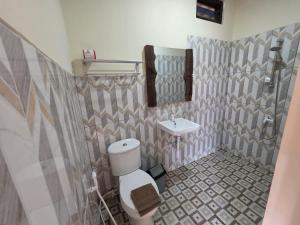 a bathroom with a toilet and a sink at Popeye Karimunjawa in Karimunjawa