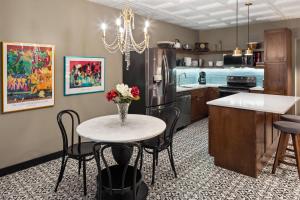 a kitchen with a table with a vase of flowers on it at The Highlander Hotel, Ascend Hotel Collection in Iowa City