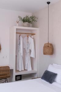 a room with a bed and white clothes on hangers at BOĒM Boutique Hotel Lefkada in Lefkada