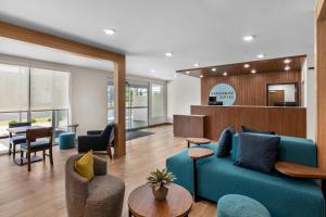 a living room with a blue couch and chairs at Everhome Suites Stockbridge Atlanta in Stockbridge