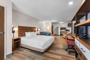 a hotel room with a large bed and a kitchen at Everhome Suites Stockbridge Atlanta in Stockbridge +35 photos
