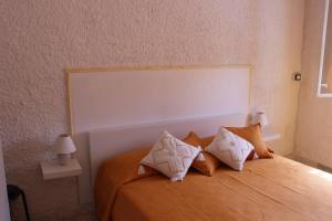 TriscinaにあるAppartamento Mediterraneoのベッドルーム(白い枕の大きなオレンジ色のベッド付)