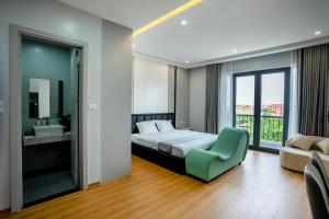 a bedroom with a bed and a chair and a window at Lumia Hotel Vinh Yen in Vĩnh Phúc