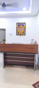 a wooden bench in a room with a picture on the wall at HoTEL SRI DURGA GRAND in Vijayawāda