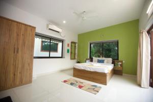 a bedroom with green walls and a bed and a window at 4BHK Villa in Anjuna with Jacuzzi & Pool in Anjuna