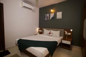 a bedroom with a white bed with a green wall at 4BHK Villa in Anjuna with Jacuzzi & Pool in Anjuna