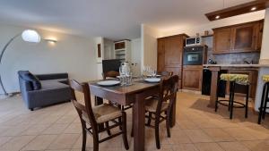 a kitchen and dining room with a wooden table and chairs at Casa Mariangela pool and garden in Leggiuno