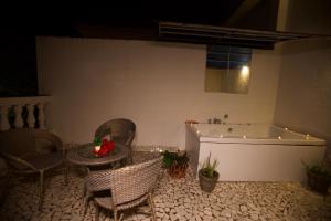 a bathroom with a tub and a table and chairs at 4BHK Villa in Anjuna with Jacuzzi & Pool in Anjuna