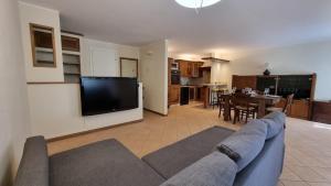 a living room with a couch and a tv and a kitchen at Casa Mariangela pool and garden in Leggiuno