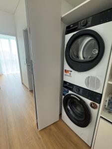 a washing machine and a washer and dryer in a room at River View Apartment in the Park in Marijampolė +9 photos