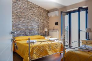 a bedroom with a bed and a brick wall at B&B MALVETUM in Malvito