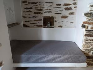 a bed sitting in a corner of a room at Μαγαζάκι in Tripótamos +5 photos