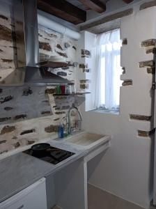 a kitchen with a sink and a stove and a window at Μαγαζάκι in Tripótamos