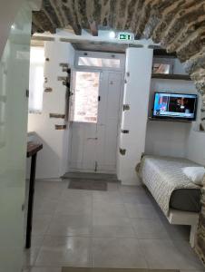 a room with a bed and a door with a tv at Μαγαζάκι in Tripótamos
