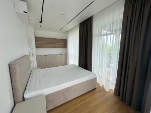 a bedroom with a bed and a large window at River View Apartment in the Park in Marijampolė