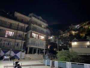 a building with lights on in a city at night at The Sukoon Vibes in Shimla +23 photos