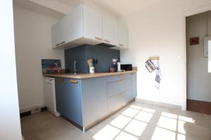a kitchen with white cabinets and a blue island at Etche alabena - 2 in Ainhoa +11 photos