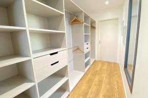 a walk in closet with white shelves at Villa des Dunes Beach 600m Private Jacuzzi Pine Forest Nature Sleeps 8 in Brem-sur-Mer