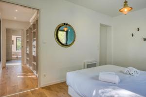 a bedroom with a white bed and a mirror at Villa des Dunes Beach 600m Private Jacuzzi Pine Forest Nature Sleeps 8 in Brem-sur-Mer
