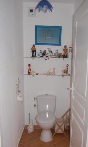 a bathroom with a toilet with figurines on shelves at Villa Aghjanella in Patrimonio