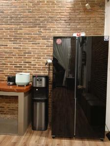 a black refrigerator next to a brick wall at Villa Sasandu Termanu in Gadog