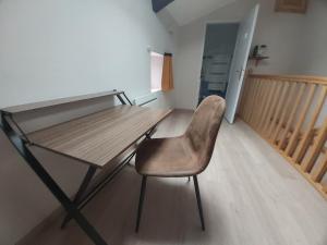 a chair sitting at a desk in a room at Maison cosy en pierre parking centre in Vittel