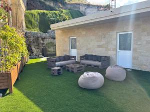 a patio with couches and tables on a lawn at Le AVRA MONTIS in Galata