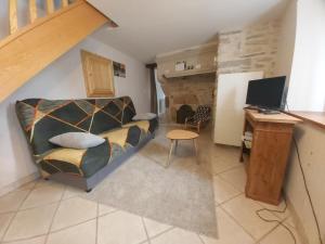 a living room with a couch and a desk with a computer at Maison cosy en pierre parking centre in Vittel