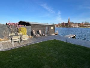 a house on a dock next to a body of water at Ferienwohnung Klosterblick Insel Malchow mit eigenen Bootsanleger in Malchow