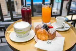 a table with two cups of coffee and pastries at Monforte's Etna Loft in Piedimonte Etneo