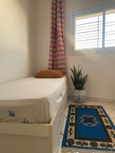 a bedroom with a bed and a window and a rug at Cozy Retreat in Bou Ficha +2 photos