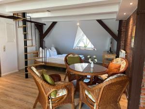 a living room with a table and chairs and a bed at Ferienwohnung Klosterblick Insel Malchow mit eigenen Bootsanleger in Malchow