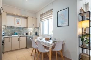a kitchen with a table and chairs in a room at Phoebes Place At Kalamaki Court, 2 Bedroom Villa With A Shared Pool - Fully Refurbished For 2026 in Kalamaki