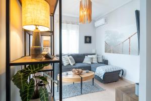 a living room with a couch and a table at Phoebes Place At Kalamaki Court, 2 Bedroom Villa With A Shared Pool - Fully Refurbished For 2026 in Kalamaki